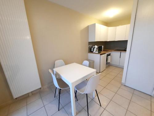 a small kitchen with a white table and chairs at L'Apollinaire - 34m2 avec balcon et parking privé in Saint-Apollinaire