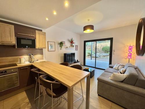 une cuisine et un salon avec une table et un canapé dans l'établissement Rena Bianca tout confort proche plage et centre ville, à Propriano