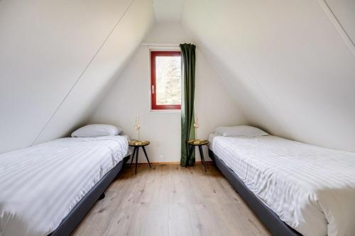 Una cama o camas en una habitación de Gekraagde Roodstaart I Bungalow met Fijne Groene Tuin