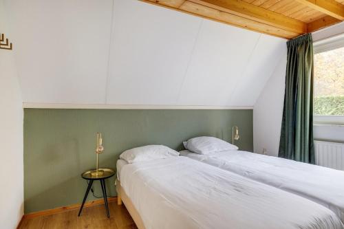Una cama o camas en una habitación de Gekraagde Roodstaart I Bungalow met Fijne Groene Tuin