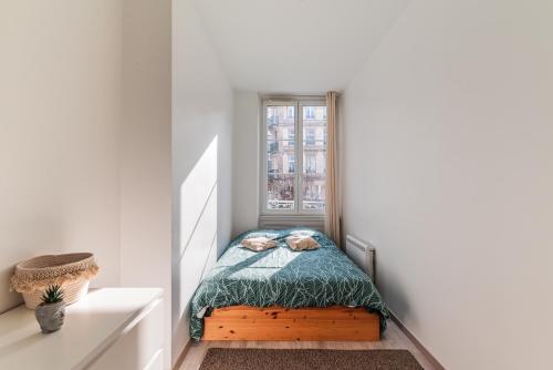 un petit lit dans une chambre avec une fenêtre dans l'établissement Chaleureux & Lumineux T3 Strasbourg-Centre, à Strasbourg
