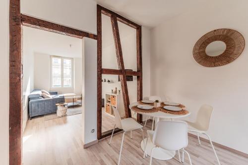 un salon blanc avec une table et des chaises dans l'établissement Chaleureux & Lumineux T3 Strasbourg-Centre, à Strasbourg