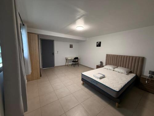 a bedroom with a bed and a table in it at Appartement Toucan in Cayenne