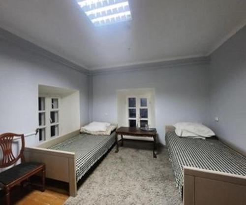 a bedroom with two beds and a chair and a skylight at Salų dvaro kultūros ir laisvalaikio rezidencija in Salos