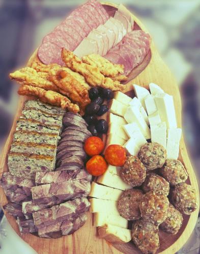 a plate of food with meats and cheese and meatballs at Voinescu House - Natural Living & Eating in Şimon