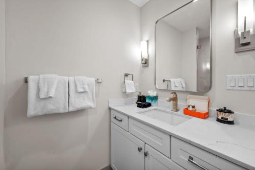 a white bathroom with a sink and a mirror at ElevateA Rooftop - Silverthorne in Coffeyville