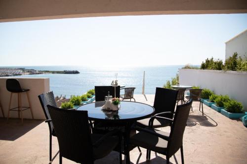 a table and chairs on a patio with a view of the ocean at Hotel Iulia Resort in Venus
