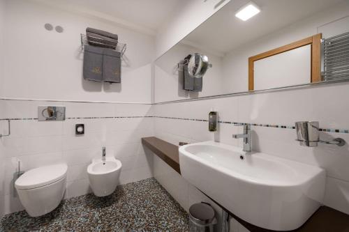 a white bathroom with a sink and a toilet at Laguna Park Hotel 4Superior in Bibione