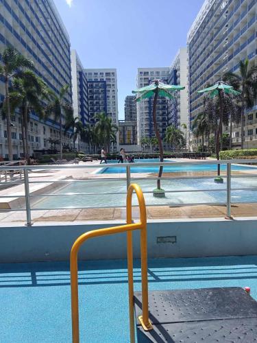 a yellow handrail in front of a pool with buildings at CHIC ROOM pasay sea residence in Manila