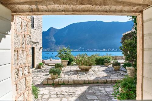 an archway with potted plants and a view of the water at Waterfront Historical Villa Perast in Perast
