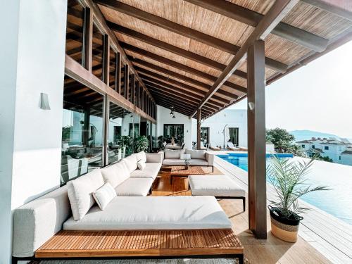 an outdoor patio with white couches and a swimming pool at Luxury Boutique B&B - Villa Prana Marbella in Ojén