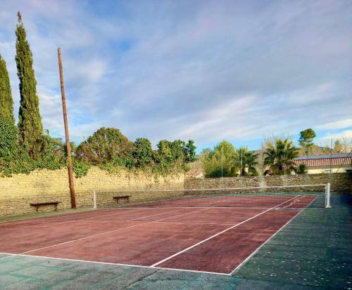 a tennis court with two benches on it at Chambres d'hôtes Sous L'Olivier in Trausse