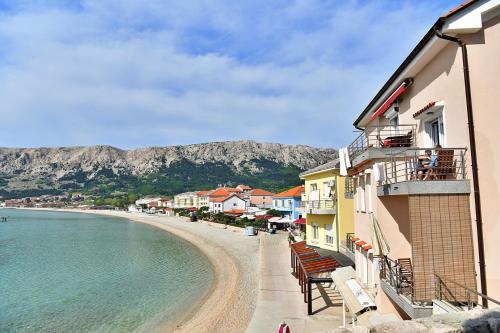a view of a beach next to a building at Apartments Barbalic Beach in Baška