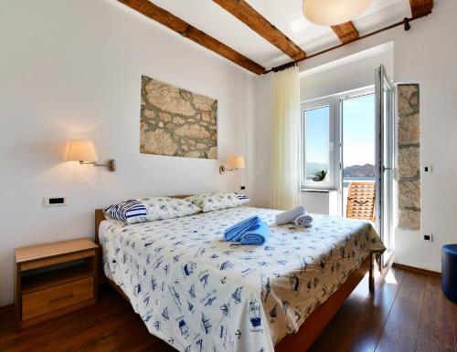 a bedroom with a bed and a window at Apartments Barbalic Beach in Baška