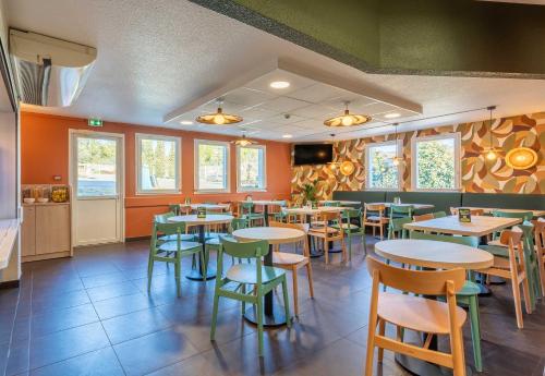 un restaurant avec des tables et des chaises dans une salle dans l'établissement B&B HOTEL Aix-en-Provence Meyreuil Sainte-Victoire, à Meyreuil