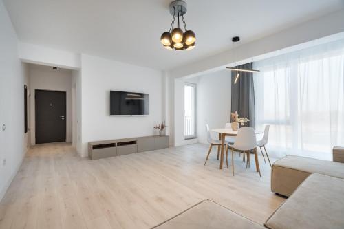 a white living room with a table and a couch at AeroPrime - LOFT in Tunari