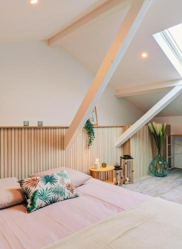 une chambre avec un grand lit dans un grenier dans l'établissement Amazone Prestige - Lyon Est, à Meyzieu