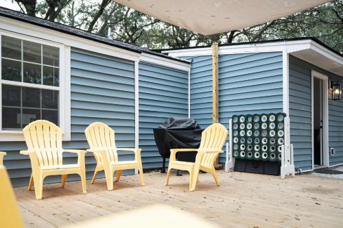 three chairs and a table on a patio at Palmetto Porch - Family Home Near Park Circle in Charleston