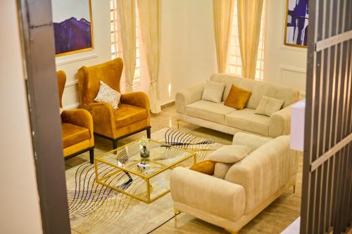 a living room with couches and chairs and a table at Bliss Haven in Lekki