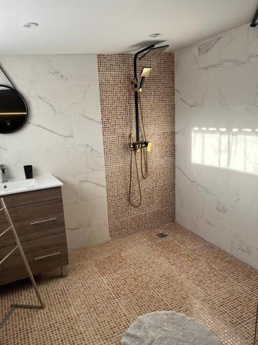 une salle de bain avec douche et lavabo dans l'établissement Le plaisir secret, à Nibas