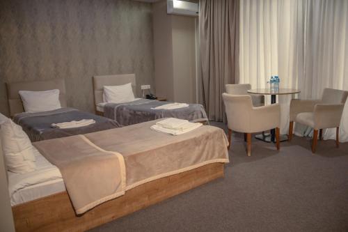 En eller flere senge i et værelse på Arena Hotel Beylagan