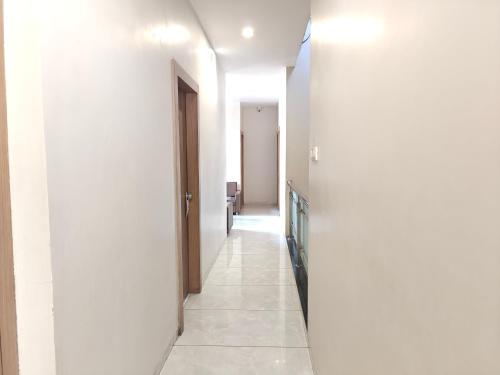 a hallway of a hospital with white walls and a door at Central Inn, Kolhapur in Kolhapur