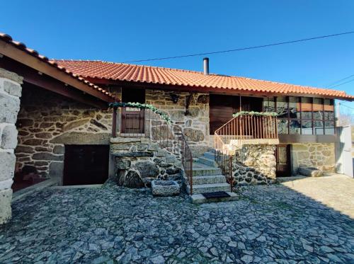 a stone house with a staircase in front of it at Casa das Falagueiras in Castro Laboreiro