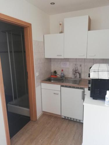 a kitchen with white cabinets and a sink at Marina Park Eberswalde in Eberswalde