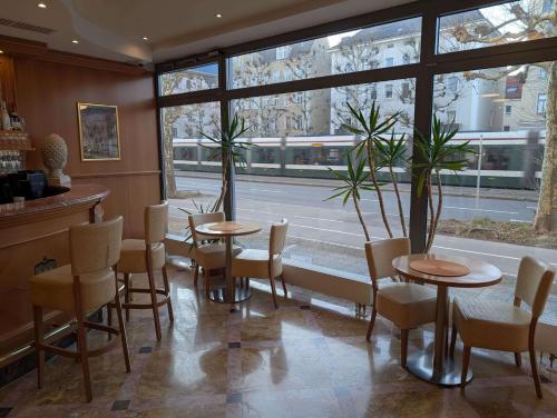 a restaurant with two tables and chairs and a window at Stadthotel Augsburg in Augsburg