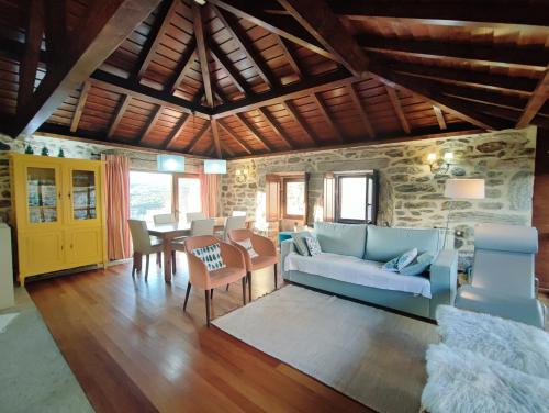a living room with a blue couch and a table at Casa das Falagueiras in Castro Laboreiro