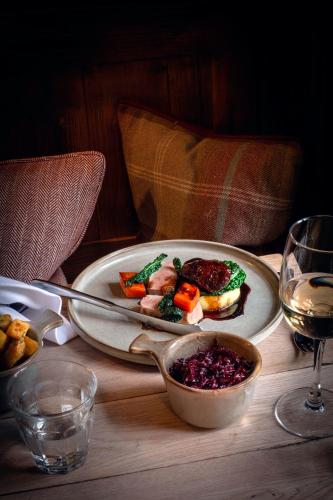 a table with a plate of food and a glass of wine at Killingworth Castle in Woodstock