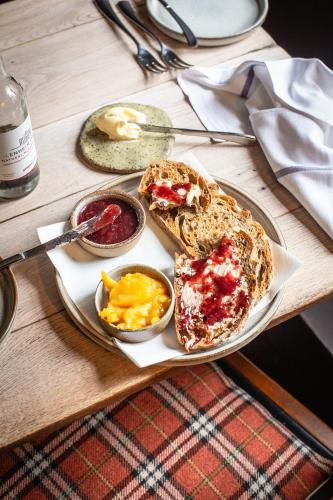 a plate with a sandwich and two bowls of fruit at Killingworth Castle in Woodstock