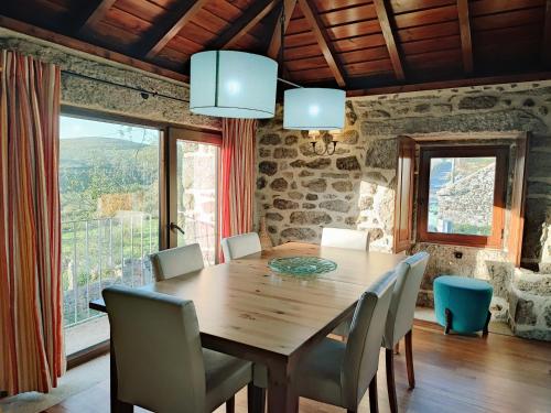 a dining room with a wooden table and chairs at Casa das Falagueiras in Castro Laboreiro