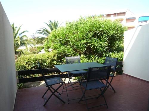 une table et des chaises bleues sur une terrasse dans l'établissement Studio cabine avec parking et climatisation à Port Camargue - FR-1-731-113, au Grau-du-Roi