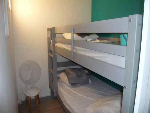 Cette petite chambre comprend 2 lits superposés et un ventilateur. dans l'établissement Studio cabine avec parking et climatisation à Port Camargue - FR-1-731-113, au Grau-du-Roi