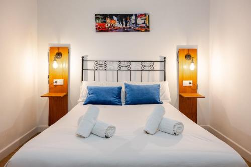 a bedroom with a large white bed with blue pillows at Casa con encanto - Wifi, aire acondicionado in Puerto Real