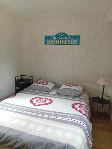 a bed in a room with a sign on the wall at Tiny House Ecuries du Vieux Moulin in Choignes