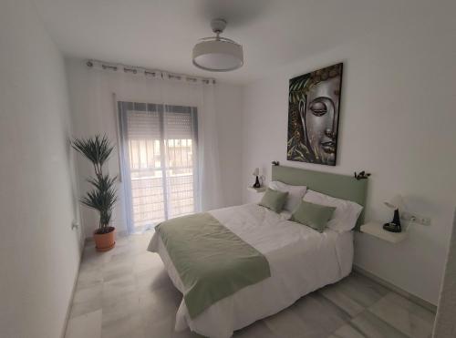 a bedroom with a bed and a painting on the wall at Hikari&Sineida Home in Rincón de la Victoria
