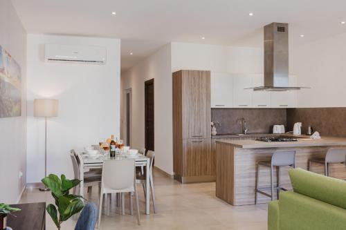 a kitchen and living room with a table and chairs at Fl 1 Thelodge - Charming Retreat By Homely in Mellieħa