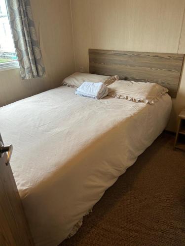 a large white bed in a room with a window at Seawick Caravan 922 in Clacton-on-Sea
