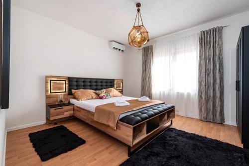 a bedroom with a large bed and a chandelier at Villa Ivan in Pridraga