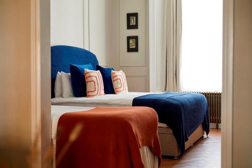 a bedroom with a bed with blue and red pillows at Georgian House Hotel in London
