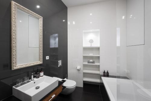 a bathroom with a sink and a toilet and a mirror at MOOo Downtown in Prague