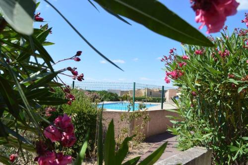 un jardin avec une piscine et des fleurs dans l'établissement SP320-619 Appartement 2 pièces SAINT PIERRE LA MER, à Saint Pierre La Mer