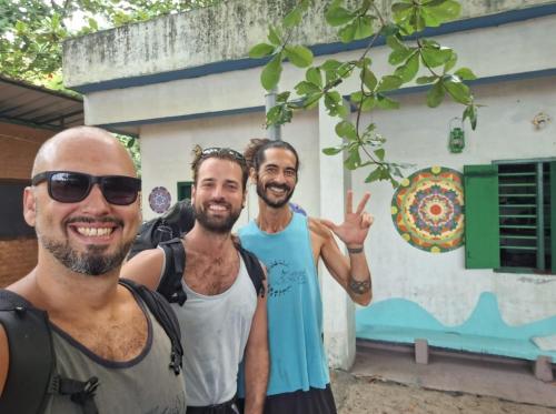 a group of three men standing in front of a building at Marari Beach Bamboo Rooms AcroYogaThai in Alleppey