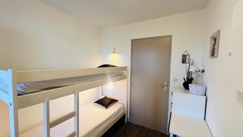 a bedroom with two bunk beds and a closet at Studio du golf, standing, piscine, forêt et océan in Saint-Jean-de-Monts