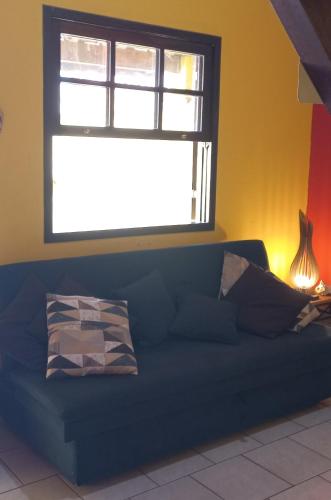 a blue couch in a room with a window at Casa Amarela in Paraty