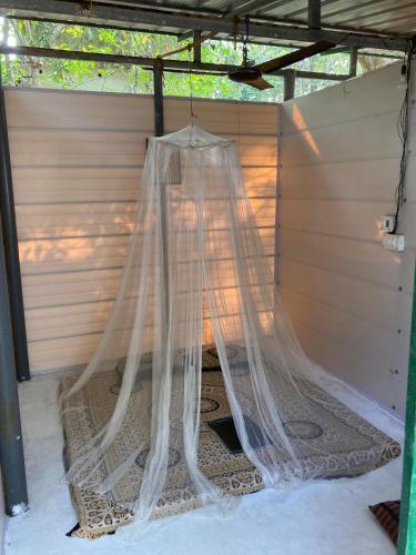 a net is hanging from a pergola at Marari Beach Bamboo Rooms AcroYogaThai in Alleppey
