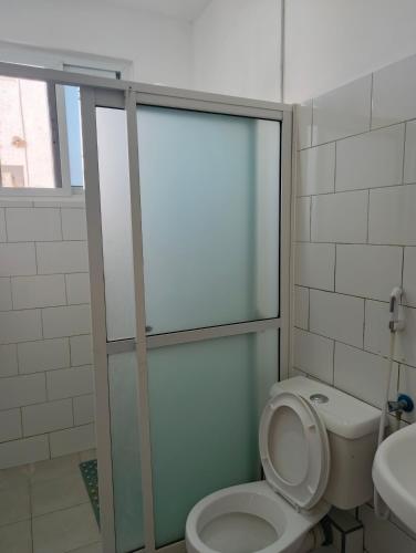 a bathroom with a toilet and a sink at Modern Couzy Suites in Malindi
