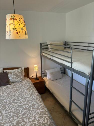 a bedroom with two bunk beds and a lamp at Casa do Campo in Carvoeiro